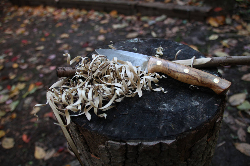 wood shavings next to a bushcraft knife